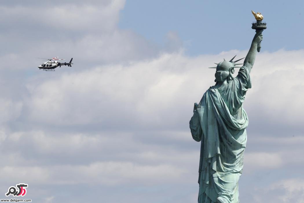 هلیکوپتر پلیس در کنار مجسمه آزادی در نیویورک در حال پرواز