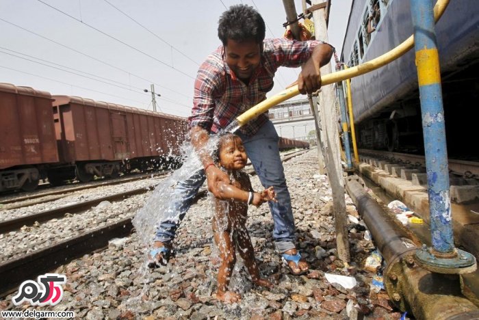 گرمای شدید هوا در الله آباد هند منجر به دوش گرفتن در کنار ریل قطار شد!