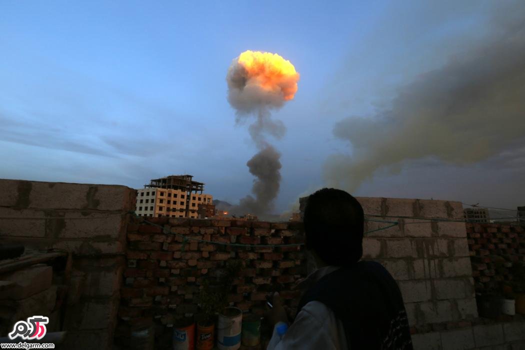 مرد یمنی در حال تماشای بمبی که توسط نیروهای عربستان سعودی پرتاب شد.
