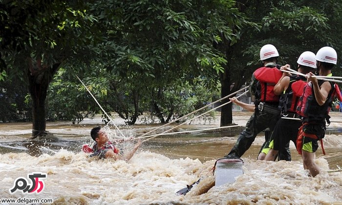 گروه امداد در حال بیرون کشیدن مردی که در اثر باران شدید در آب گیر افتاده است/چین