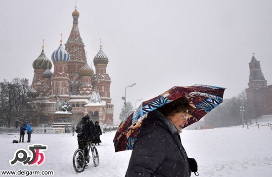عابرین پیاده در حال عبور از مقابل کلیسای جامع سنت باسیل در میدان سرخ مسکو روسیه